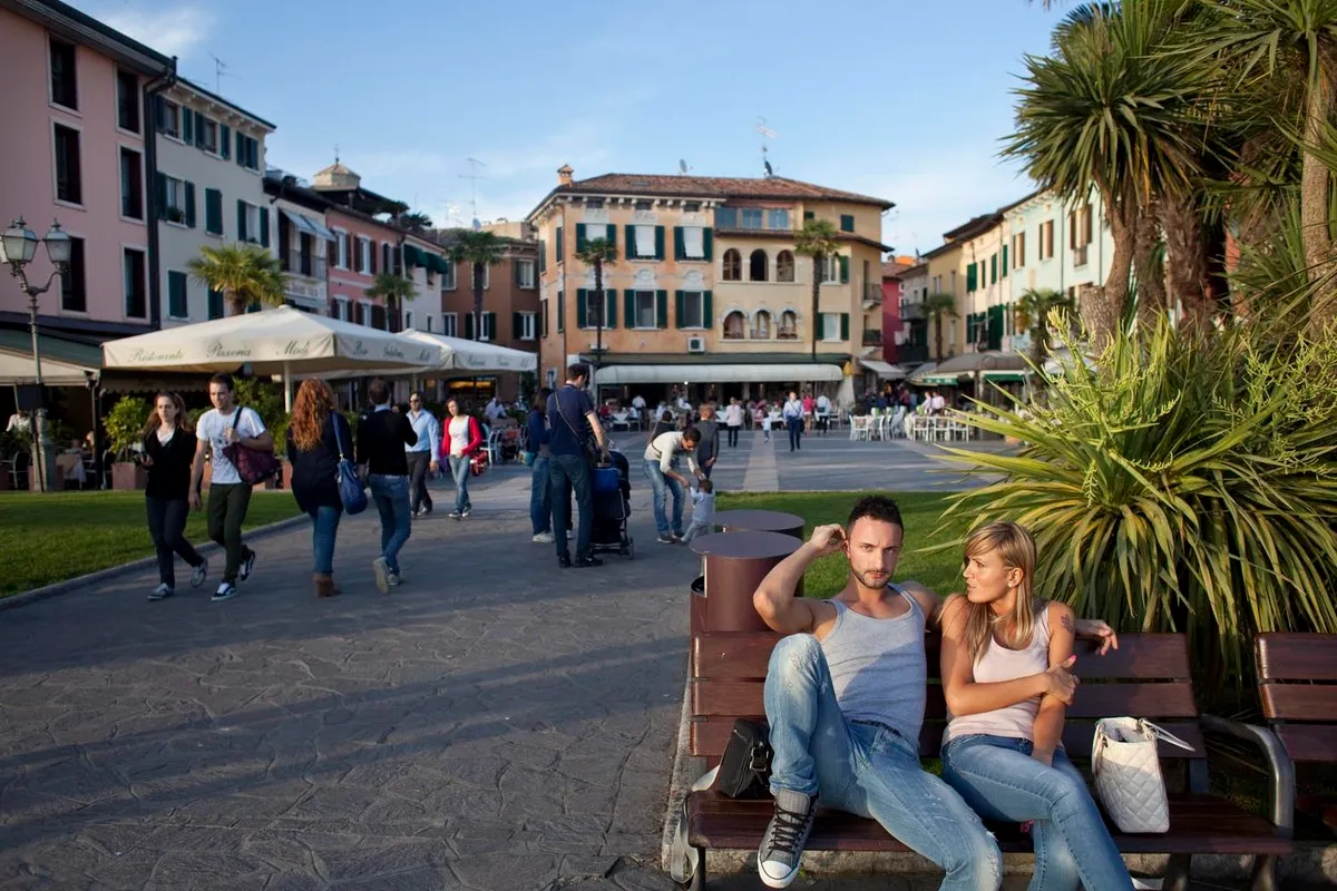 Paesaggio urbano con palma e persone a sedere - Fotografia di Enrico Fantoni